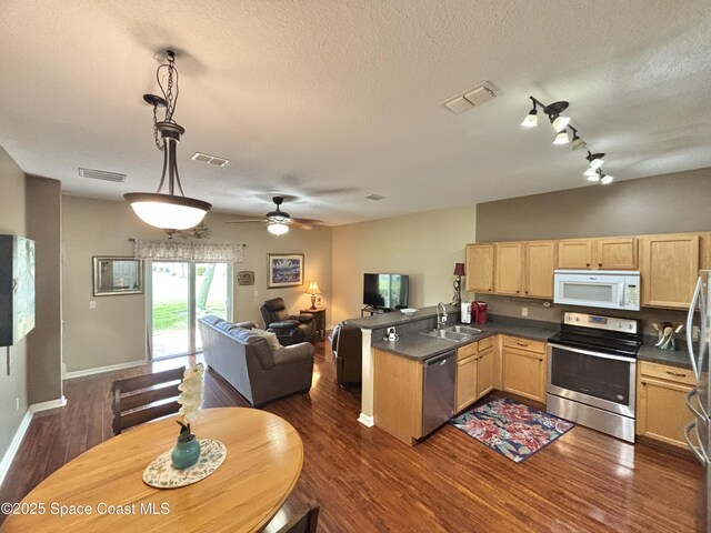 2650 Revolution St Unit 104, Melbourne, FL 32935 - kitchen with stainless steel appliances, light brown cabinetry, a sink, open floor plan, and a peninsula