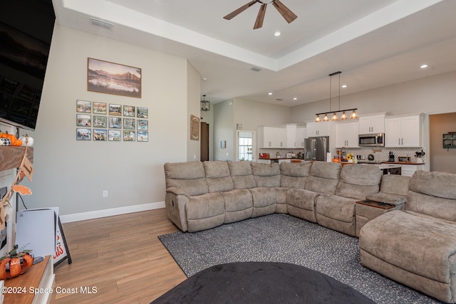 living room with ceiling fan and light hardwood / wood-style floors