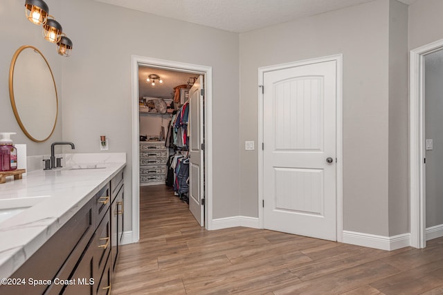 bathroom with vanity, wood-type flooring, and a textured ceiling