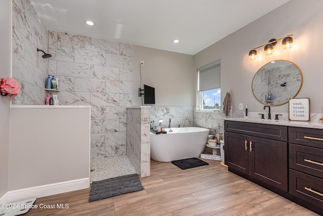 bathroom with vanity, independent shower and bath, tile walls, and hardwood / wood-style flooring