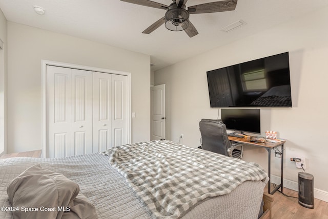 bedroom with ceiling fan, a closet, and light hardwood / wood-style flooring