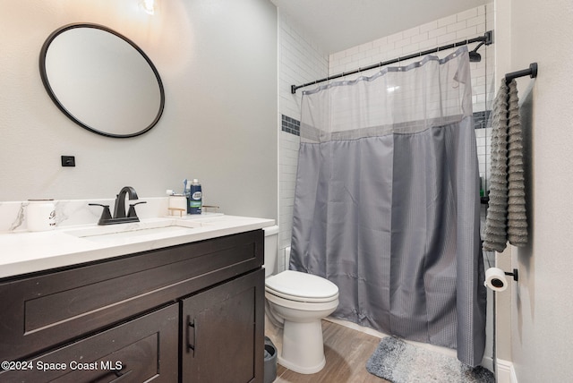 full bathroom with hardwood / wood-style flooring, vanity, shower / bath combination with curtain, and toilet