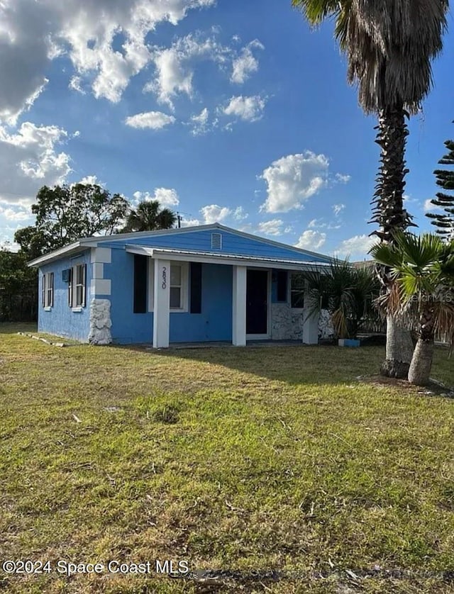 rear view of property with a yard