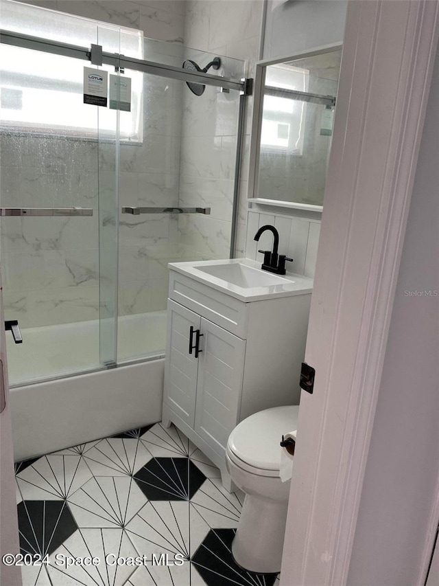 full bathroom featuring tile patterned flooring, vanity, toilet, and enclosed tub / shower combo