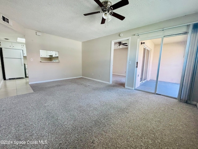 unfurnished living room with a textured ceiling, light colored carpet, and ceiling fan