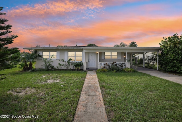 view of front of house with a yard and a carport