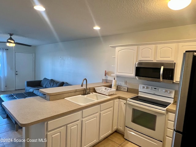 kitchen featuring kitchen peninsula, white cabinetry, sink, and appliances with stainless steel finishes