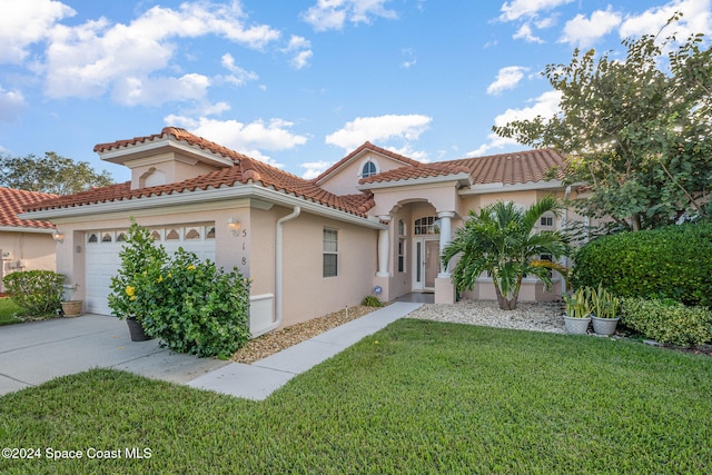 mediterranean / spanish home with a garage and a front yard