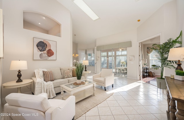 living room featuring light tile patterned floors, lofted ceiling, and a notable chandelier