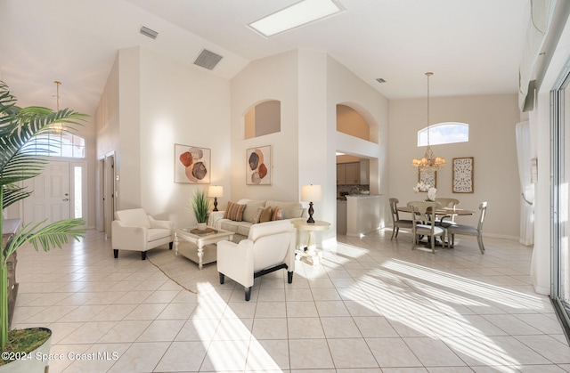 tiled living room with high vaulted ceiling and a chandelier