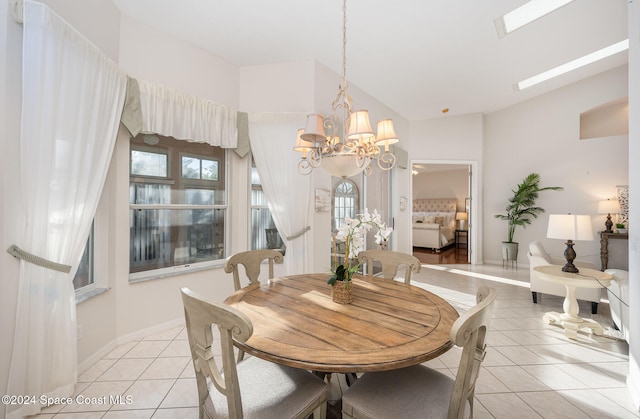 tiled dining room featuring vaulted ceiling with skylight and an inviting chandelier