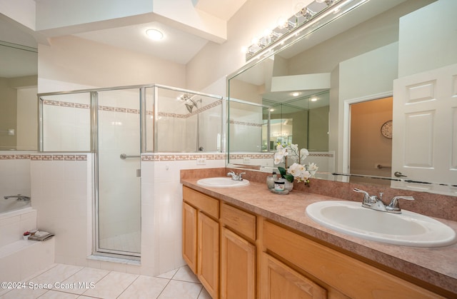 bathroom with tile patterned floors, vanity, and shower with separate bathtub