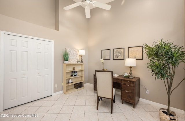 office area with a high ceiling, light tile patterned floors, and ceiling fan