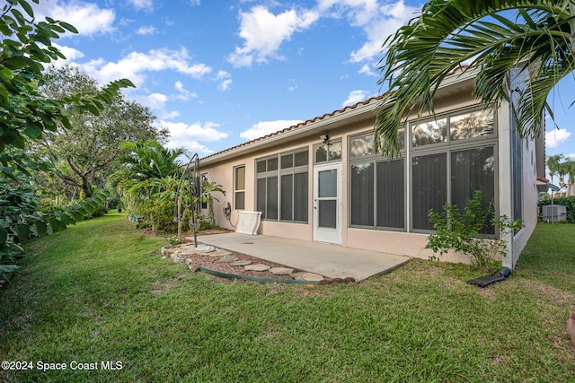 back of house featuring a patio, cooling unit, and a lawn