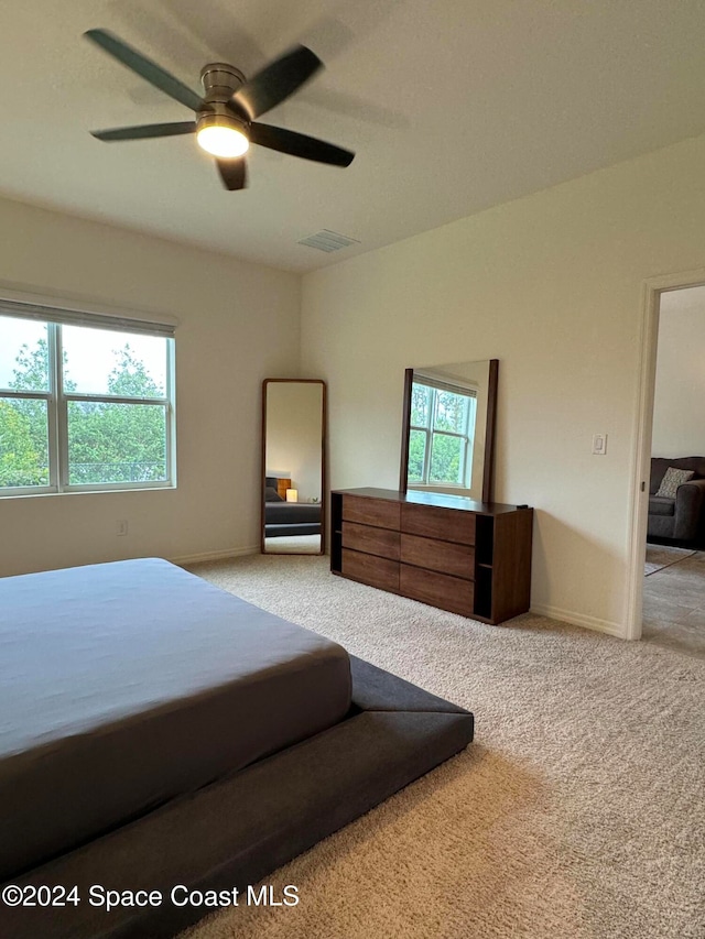 bedroom featuring carpet floors, multiple windows, and ceiling fan