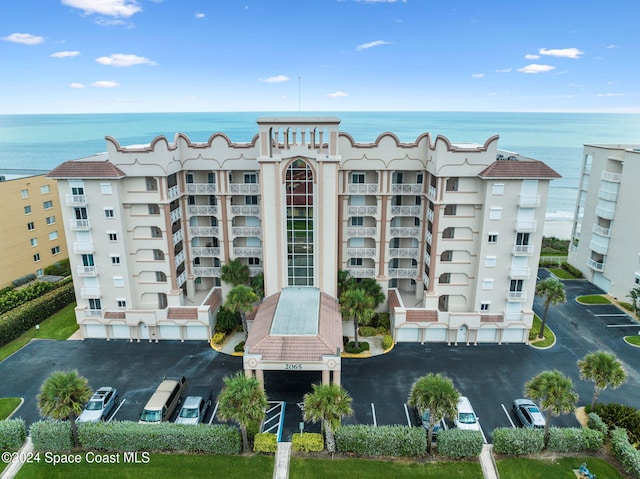 view of property with a water view and uncovered parking