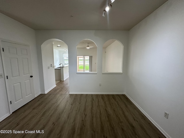 spare room with dark hardwood / wood-style flooring and ceiling fan