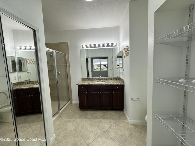 bathroom with a shower with door, vanity, and toilet