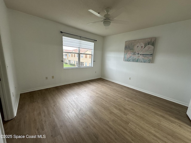 spare room featuring ceiling fan and dark hardwood / wood-style flooring