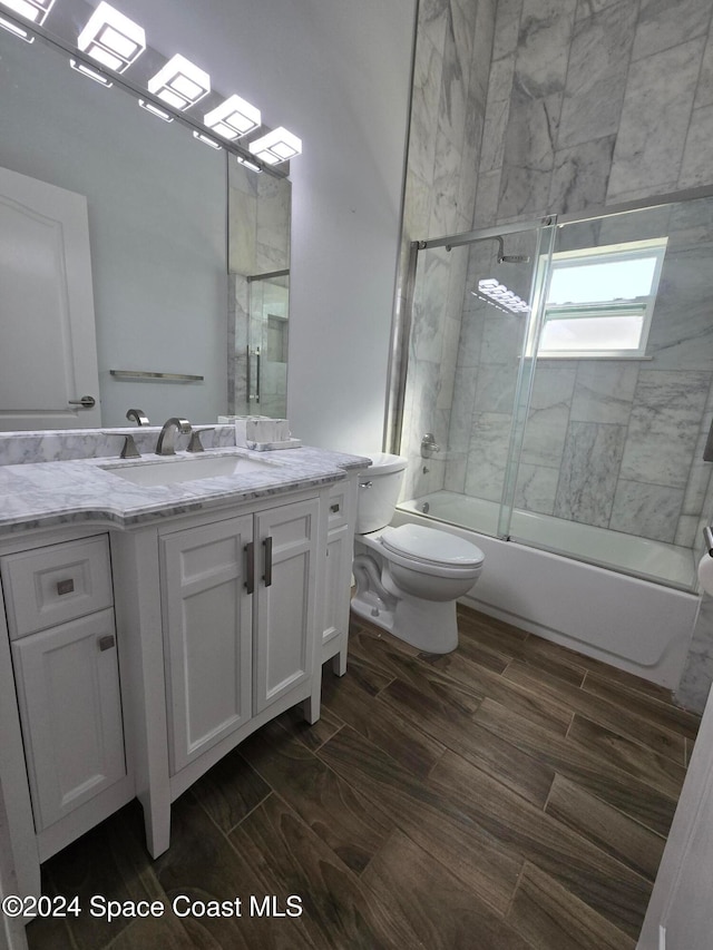 full bathroom featuring enclosed tub / shower combo, toilet, and vanity