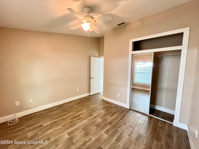 unfurnished bedroom with a closet, hardwood / wood-style floors, and ceiling fan