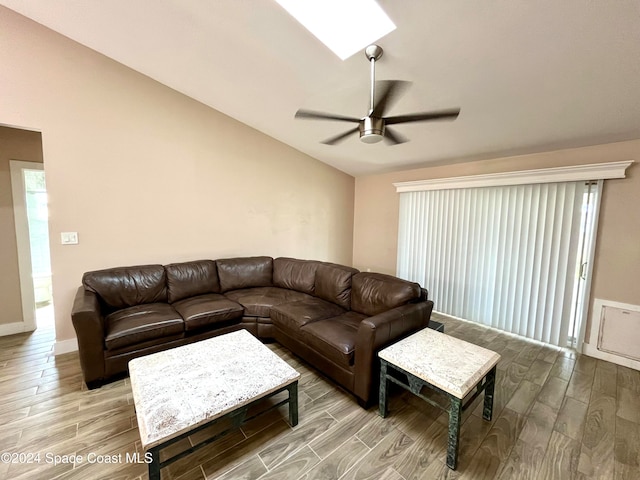 living room featuring ceiling fan, wood-type flooring, and lofted ceiling with skylight