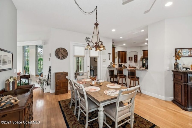 dining space with light hardwood / wood-style floors and a chandelier