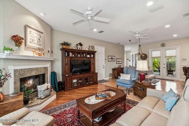 living room featuring a fireplace, french doors, and light hardwood / wood-style flooring