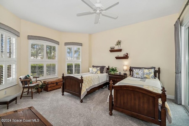 carpeted bedroom with ceiling fan and multiple windows