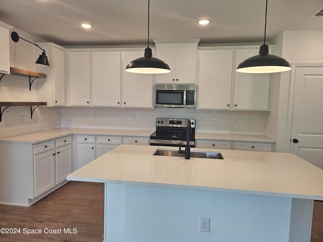 kitchen featuring white cabinets, hanging light fixtures, and appliances with stainless steel finishes