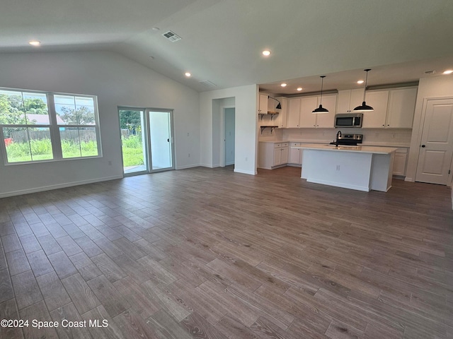 kitchen with wood-type flooring, white cabinetry, pendant lighting, and appliances with stainless steel finishes