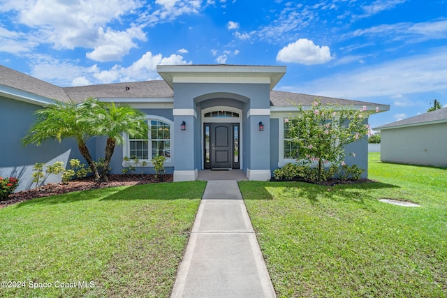 property entrance with a lawn