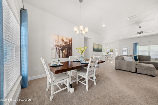 carpeted dining space featuring ceiling fan with notable chandelier