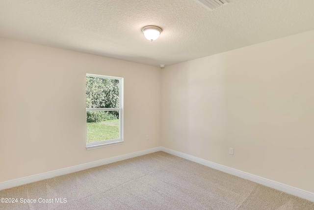 unfurnished room featuring a textured ceiling and carpet floors