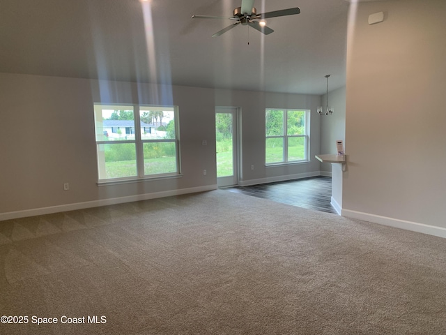 139 Whirl St SW, Palm Bay, FL 32908 - unfurnished living room with carpet floors, baseboards, a ceiling fan, lofted ceiling, and a chandelier