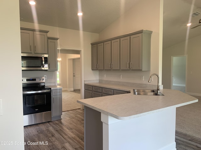 139 Whirl St SW, Palm Bay, FL 32908 - kitchen with stainless steel appliances, lofted ceiling, a sink, gray cabinets, and light countertops