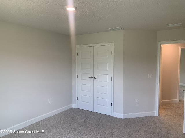 139 Whirl St SW, Palm Bay, FL 32908 - unfurnished bedroom with carpet flooring, a textured ceiling, a closet, and baseboards