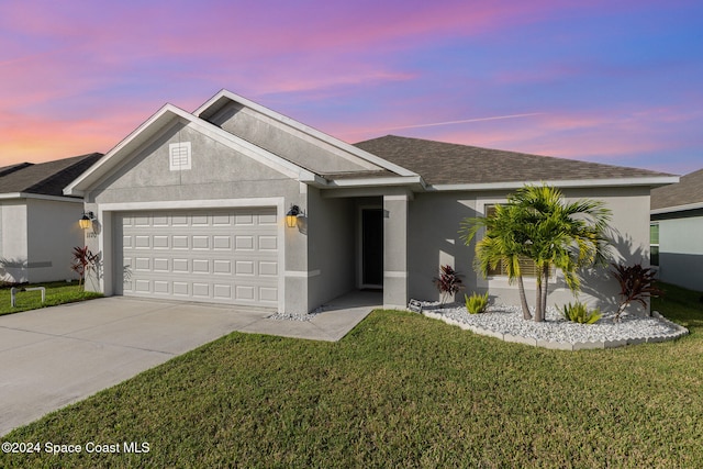 ranch-style house featuring a garage and a lawn