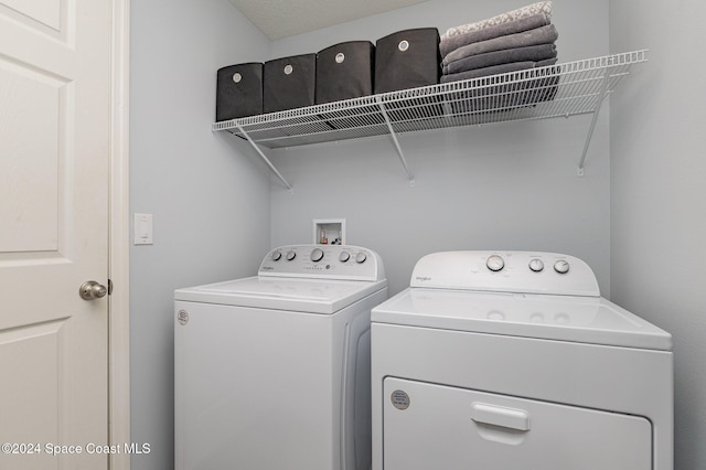 clothes washing area with washer and clothes dryer