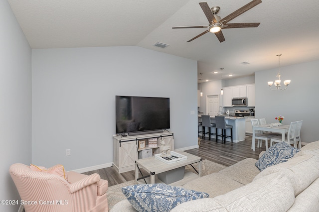 living room featuring lofted ceiling, ceiling fan with notable chandelier, sink, a textured ceiling, and dark hardwood / wood-style flooring