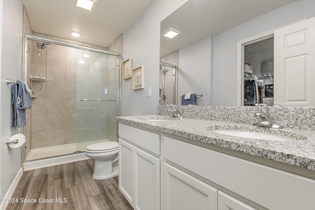 bathroom featuring vanity, toilet, wood-type flooring, and walk in shower