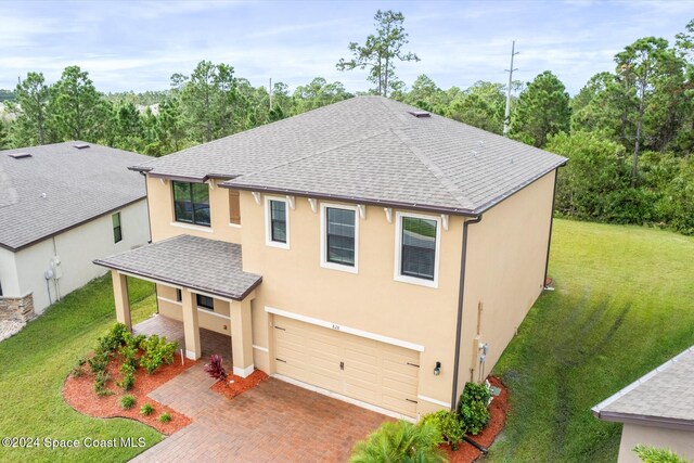 view of front of house featuring a front lawn and a garage