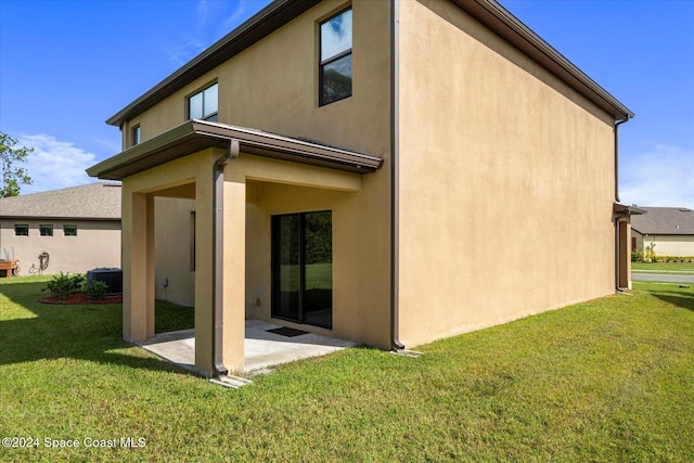 rear view of property featuring a patio area and a lawn