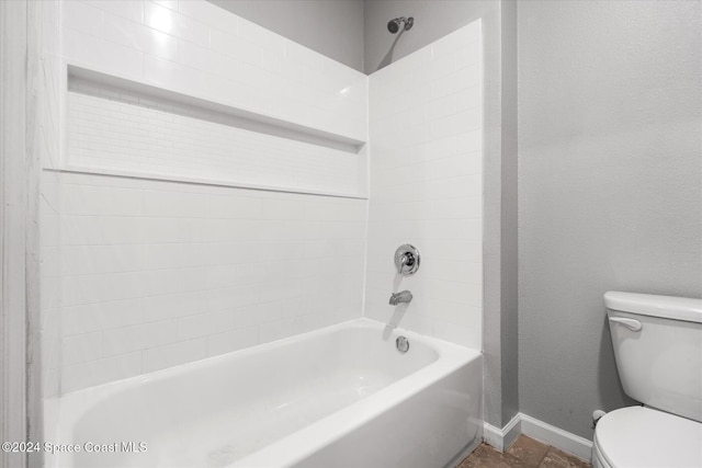 bathroom with toilet and tiled shower / bath