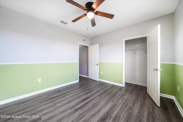 unfurnished bedroom featuring ceiling fan, dark hardwood / wood-style floors, and a closet