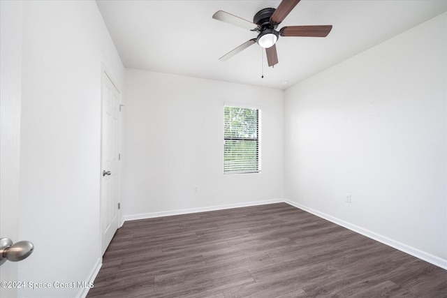 spare room with dark wood-type flooring and ceiling fan