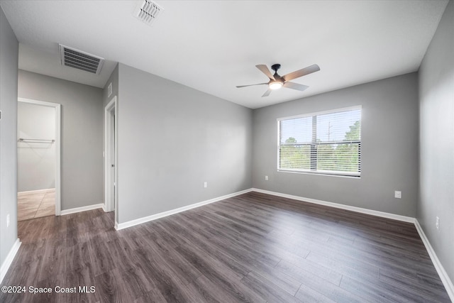 empty room with dark wood-type flooring and ceiling fan