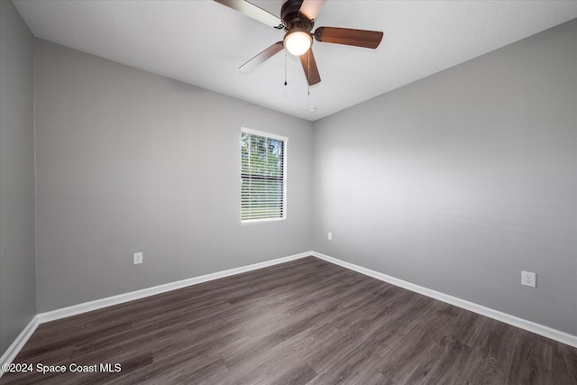 unfurnished room featuring dark wood-type flooring and ceiling fan