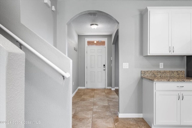 tiled entrance foyer with a textured ceiling