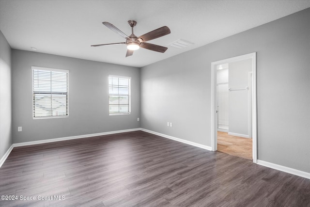 empty room with dark hardwood / wood-style flooring and ceiling fan